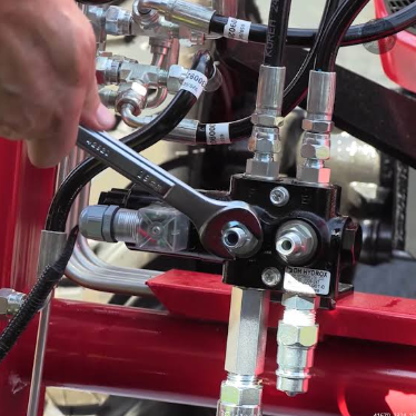 Professional hydraulic valve installation with labeled hoses and fittings